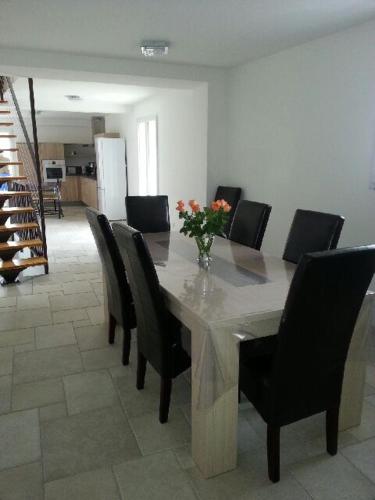 a dining room table with chairs and a vase of flowers on it at La Magnanerie de Fontfreyde in Gras