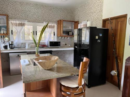a kitchen with a black refrigerator and a counter at SOUTH HILL VILLA in Mahe