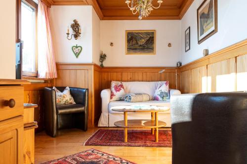Aberseeblick Pension Ellmauer في سانت ولفغانغ: غرفة معيشة مع أريكة وطاولة