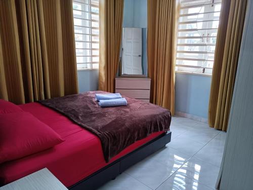 a bedroom with a bed with red sheets and a mirror at BJ villa homestay in Kuala Terengganu