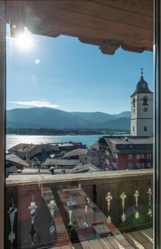 a view from a window of a town with a clock tower at Aberseeblick Pension Ellmauer in St. Wolfgang