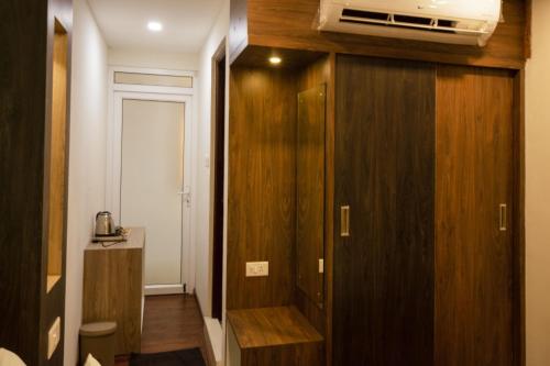 um quarto com um armário de madeira e uma ventoinha no tecto em Hotel Ramtel inn em Madurai