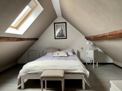 a bedroom with a bed in a attic at Maison de village chez Josy in Coudun