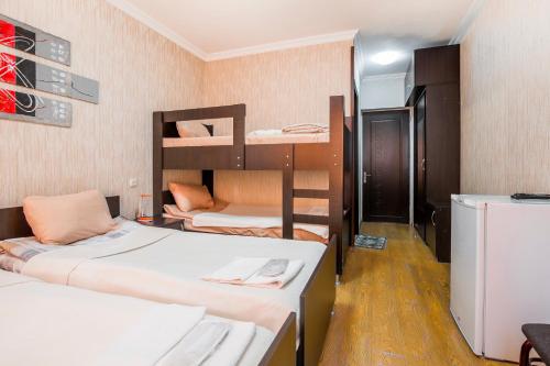 Habitación con 3 literas y nevera. en Alma-Ata Hotel, en Borjomi