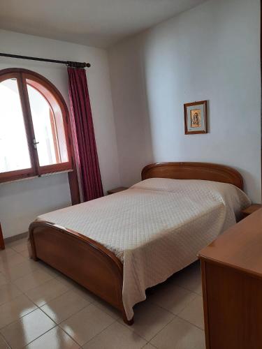 1 dormitorio con 1 cama y ventana en una habitación en Casa Ercole, en Torre dell'Orso