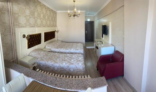 a small room with two beds and a red couch at Termal Elit Hotel in Gokcedere