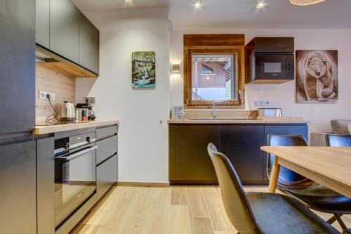une cuisine avec une table en bois et une salle à manger dans l'établissement Carlina 101, à Morzine