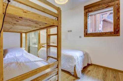 een slaapkamer met 2 stapelbedden en een raam bij Carlina 101 in Morzine