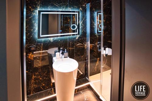 a bathroom with a sink and a mirror at LIFE VOYAGE & SPA - Strasbourg's City Center Luxury Experience in Strasbourg