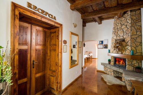 a hallway with a wooden door and a stone fireplace at Penzión Zemianska kúria in Dolný Kubín
