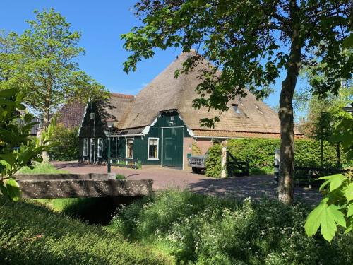 a large green house with a thatched roof at Olga Hoeve in Twisk