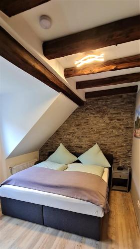 a bed in a room with a brick wall at Ferienwohnung am Fluß in Klotten