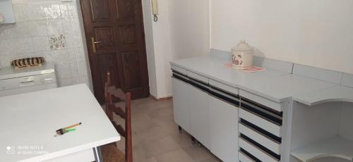 Appartamento Olimpo: Biella في بييلا: مطبخ أبيض مع كونتر أبيض وطاولة