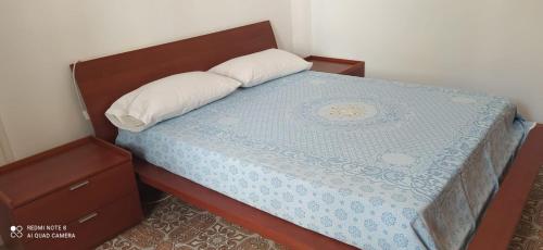een slaapkamer met een bed met een blauw dekbed bij Appartamento Olimpo: Biella in Biella