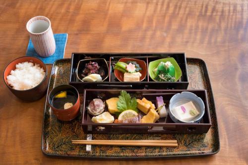 a tray of food with sushi and chopsticks on a table at Kyomachiya Suite Rikyu in Kyoto