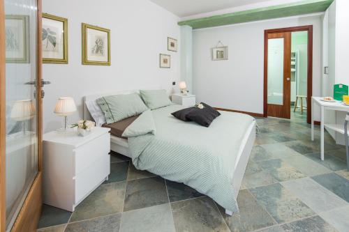a white bedroom with a bed and a bathroom at La Casa di Linda in Mirano