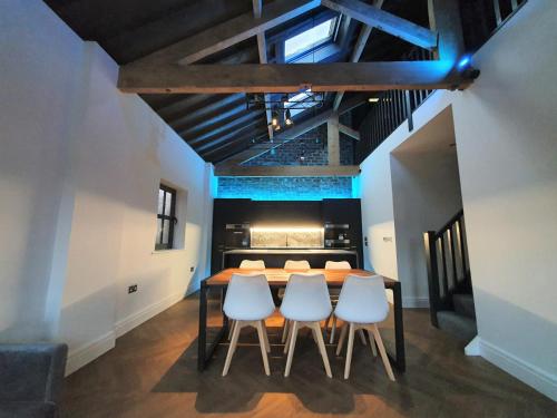 a dining room with a table and four chairs at The Eden Warehouse - Green Apartment, sleeps 5 in Southport