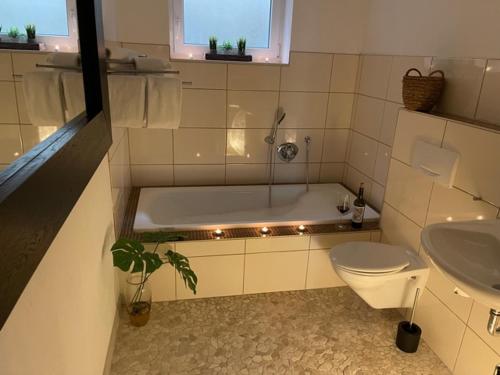 y baño con bañera, aseo y lavamanos. en Appartement Luna, en Ruppach-Goldhausen