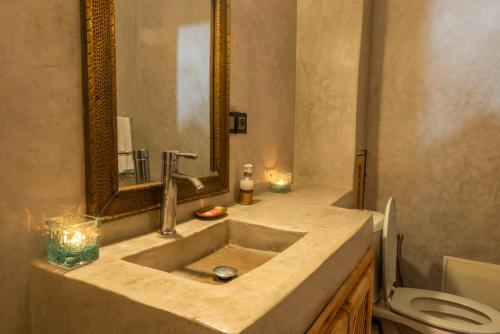 y baño con lavabo, aseo y espejo. en Riad Abjaou, en Marrakech