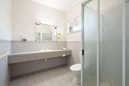 a bathroom with a toilet and a sink and a shower at Comfort Inn & Suites King Avenue in Sale