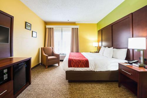 a hotel room with a bed and a chair at Comfort Inn & Suites Dayton Northwest - Englewood in Dayton