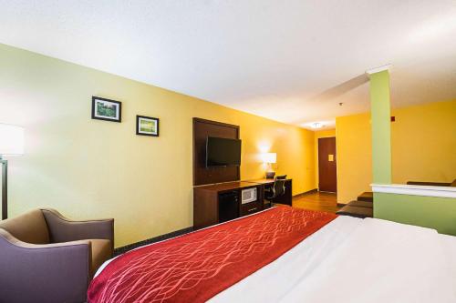 a hotel room with a large bed and a flat screen tv at Comfort Inn & Suites Dayton Northwest - Englewood in Dayton