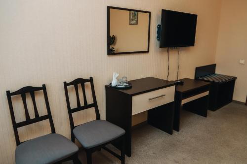 a room with a desk and two chairs and a mirror at Готель Релакс in Korostyshiv