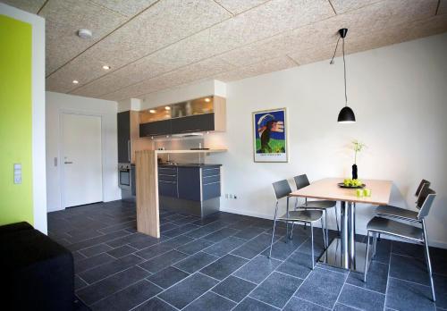 a kitchen and dining room with a table and chairs at Hotel Strandtangen in Skive
