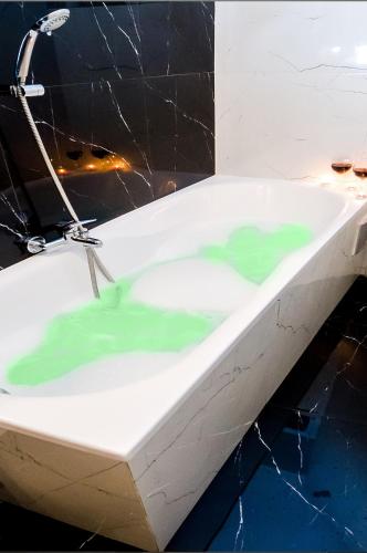a bath tub filled with green green water at Cracovia Wawel Apartments in Kraków