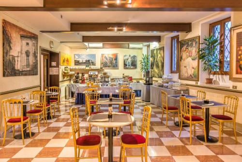 restauracja ze stołami i krzesłami w pokoju w obiekcie Hotel La Fenice et Des Artistes w Wenecji