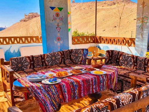 a couch with a table with plates of food on it at Nubian Kingdom Aragheed House in Aswan