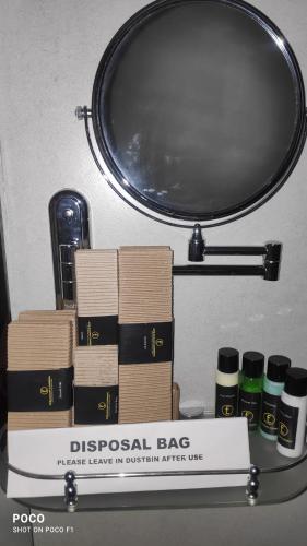 a pile of books on a shelf with a mirror at Emperor-Hotel Rachana Continental Pvt Ltd in Kizhake Chālakudi