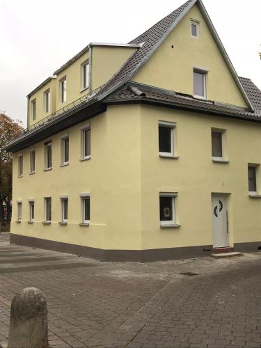 a large yellow building with a black roof at BT Apparts Stuttgart Wangen in Stuttgart