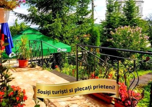 a sign for a garden with a green umbrella at Pensiunea Agroturistică Piscul Soarelui in Cîmpulung