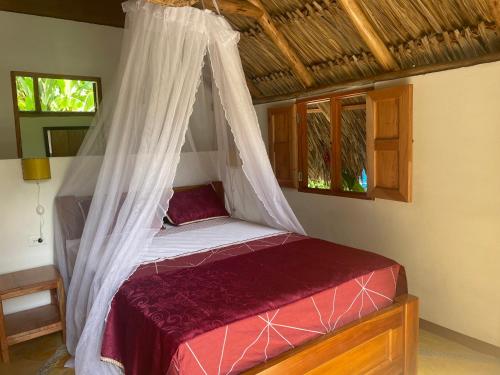 een bed met een klamboe in een kamer bij Cabañas Tucan Eco Hotel RNT 52523 in Capurganá