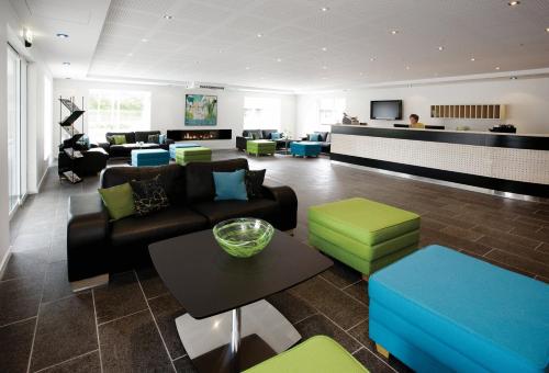 a living room with couches and chairs and a table at Hotel Strandtangen in Skive