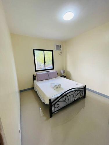 a bedroom with a bed in a room with a window at Furnished apartment Daily rental in Mactan
