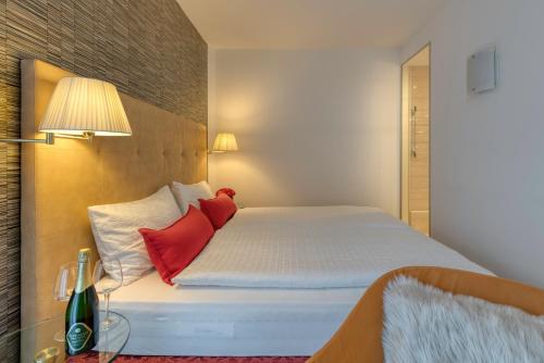 a bedroom with a bed with two red pillows at Hotel Sporting Trento in Trento