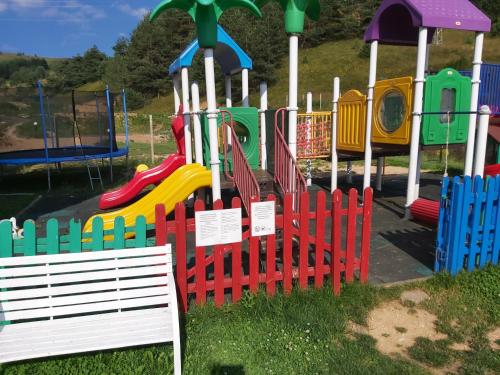 un parco giochi con una recinzione colorata e uno scivolo di Park Hotel Eagle Stone a Koprivshtitsa