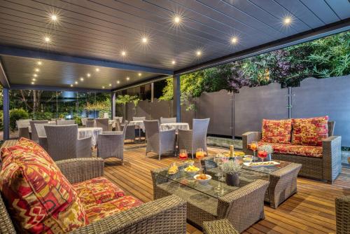 a patio with tables and chairs on a deck at Hotel Sporting Trento in Trento