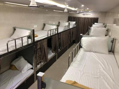 grupa łóżek piętrowych w pokoju w obiekcie ELLIOTT INN A.C DORMITORY w Bombaju