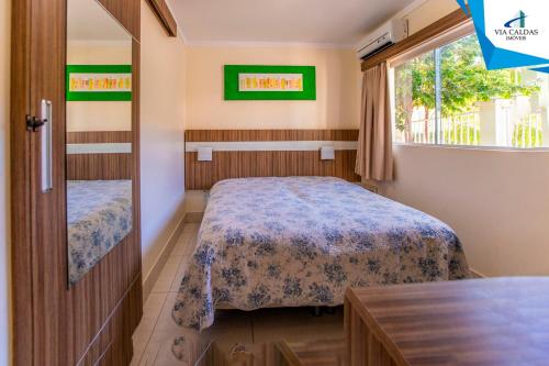 Habitación pequeña con cama y ventana en Via Caldas Lacqua IV, en Caldas Novas