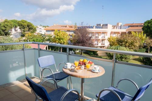 a table with a bowl of fruit on a balcony at Hotel Ancora in Palamós