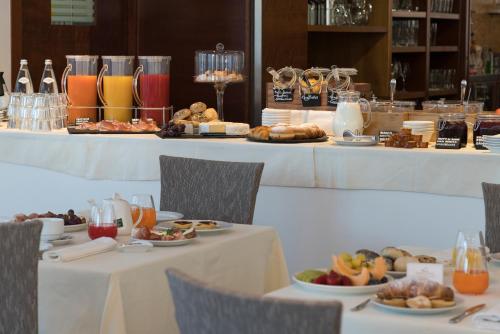 a buffet of food on tables in a restaurant at Hotel Sporting Trento in Trento