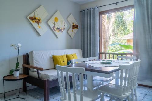 a dining room with a table and chairs and a window at Pousada Residencial dos Corais in Bombinhas