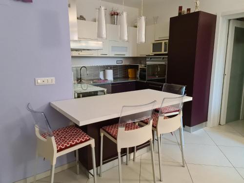 a kitchen with a white table and chairs at Memories B&B in Ferrara
