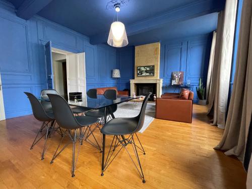 een eetkamer met blauwe muren en een tafel en stoelen bij La Petite Fontaine in Saint-Émilion