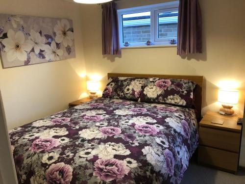 a bedroom with a bed with a floral bedspread at Seaclusion in St Austell