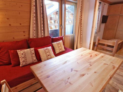 sala de estar con sofá rojo y mesa de madera en Studio Méribel, 1 pièce, 3 personnes - FR-1-182-200 en Les Allues