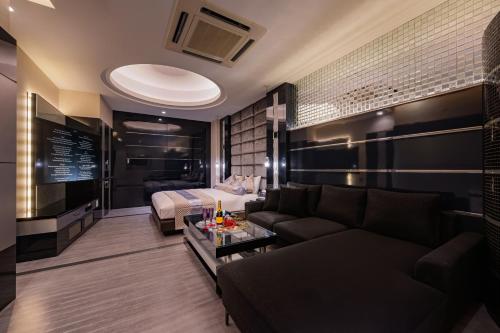a living room with a couch and a bed at HOTEL Dior7つくば in Tsuchiura